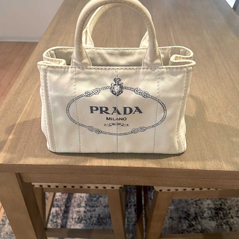 Prada Milano Italy Canvas off white shoulder tote with Navy Blue writing.